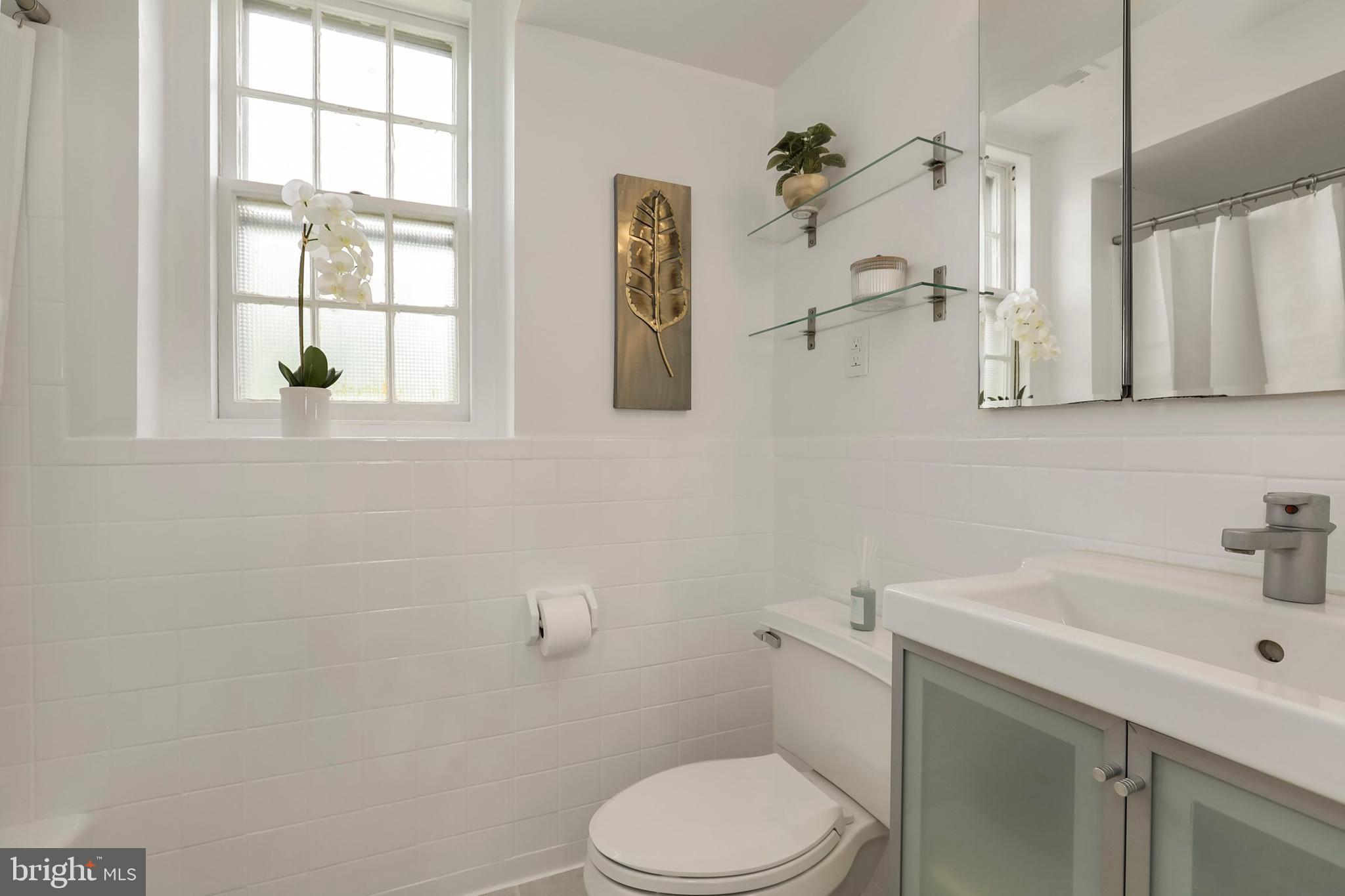 3831 Rodman Street Northwest, Unit F30 Washington, DC 20016 - Photo 21 of 33 a white toilet sitting next to a bathroom sink