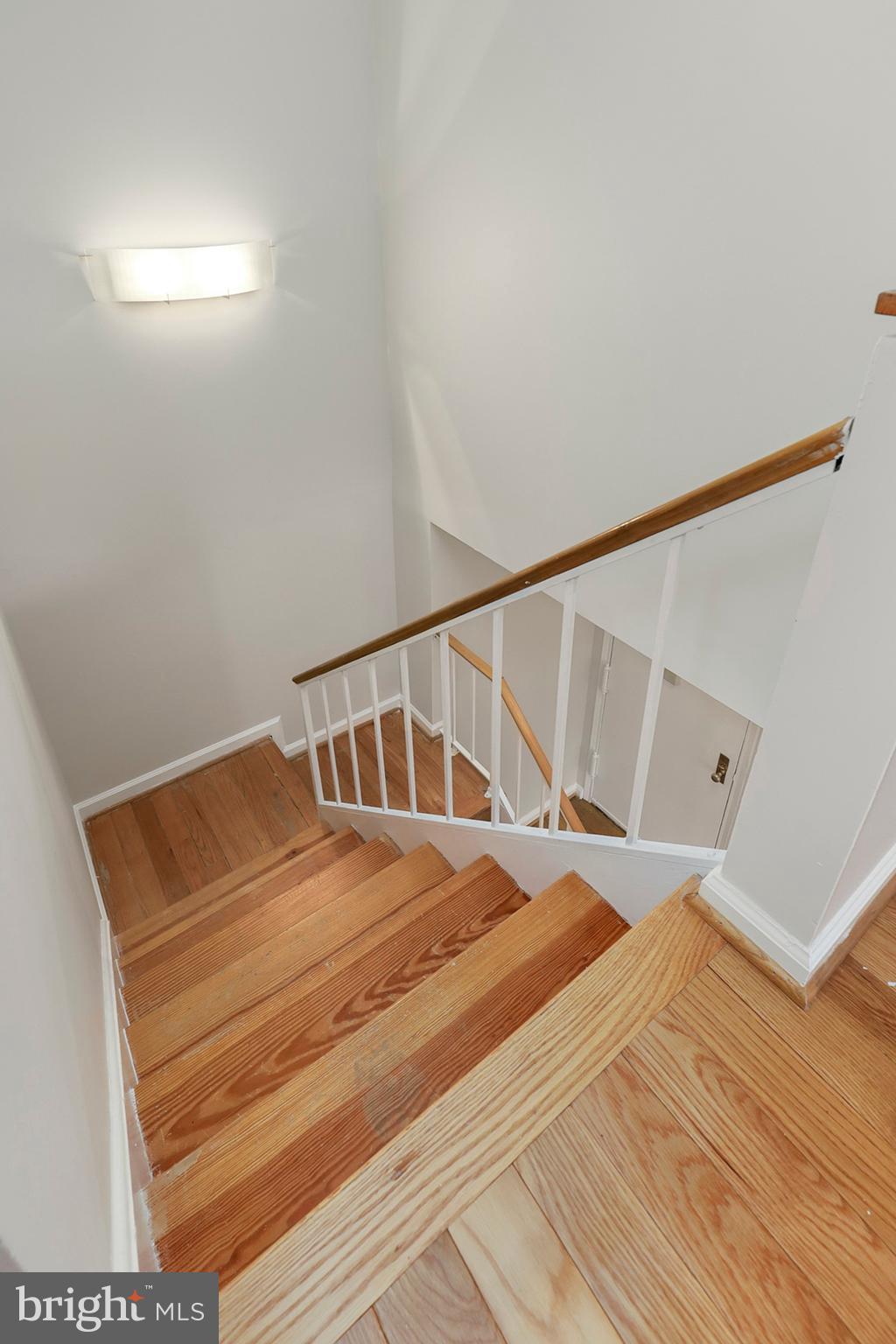 3831 Rodman Street Northwest, Unit F30 Washington, DC 20016 - Photo 25 of 33 a bedroom with a bed and wooden floor