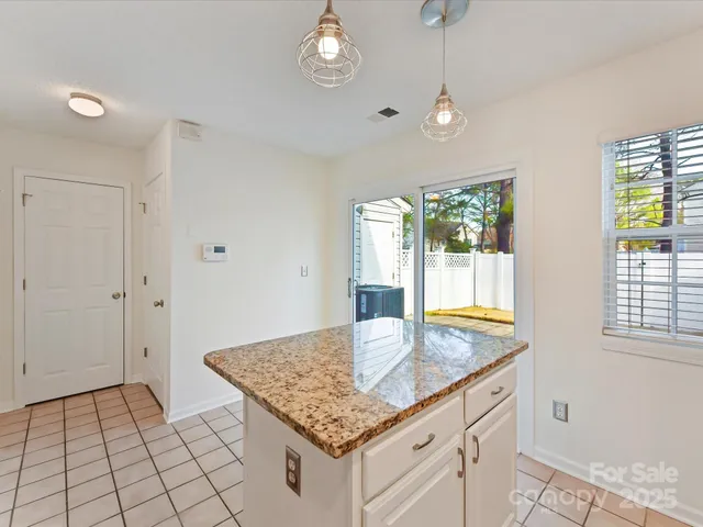 a kitchen with granite countertop a sink cabinets and window