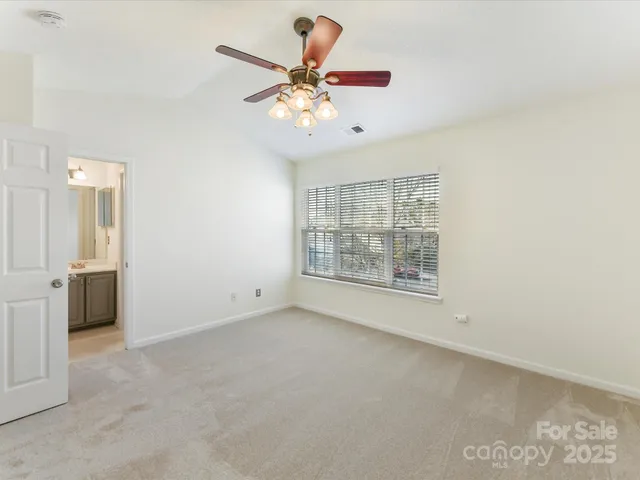 an empty room with fan and windows
