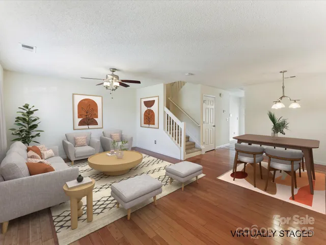 a living room with furniture a chandelier and a dining table