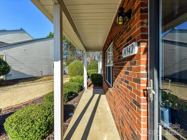 a front view of a house with a yard covered with snow