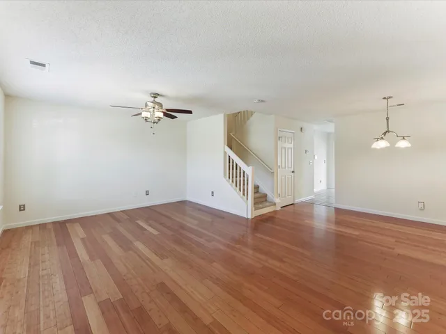 a view of a livingroom with wooden floor and a ceiling fan