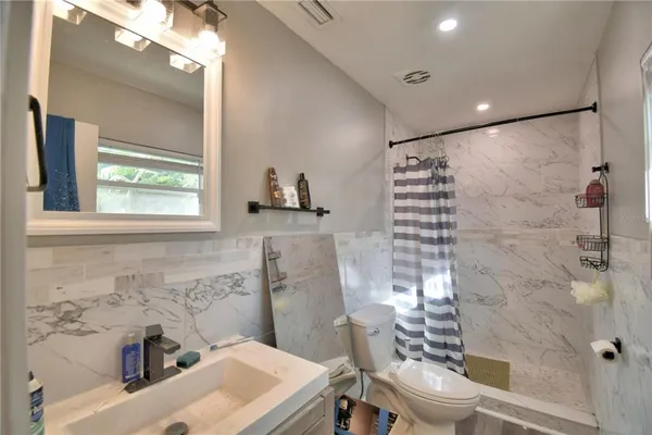 a bathroom with a sink toilet and shower