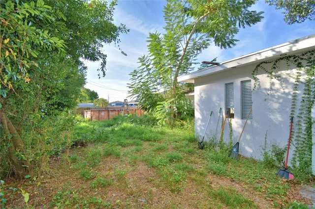 a view of a yard in front of a house with large trees