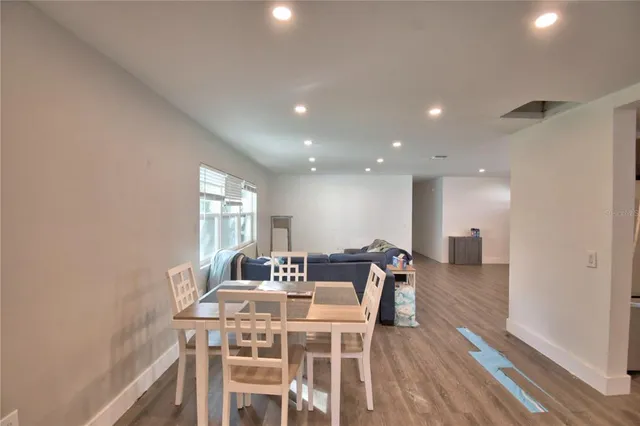 a view of a a dining room with furniture window and wooden floor