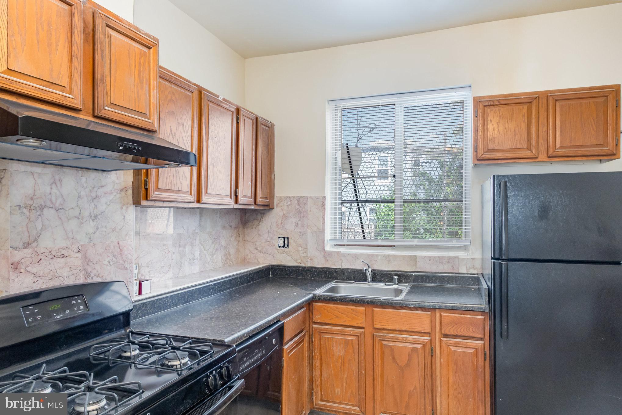 2544 West Fairmount Avenue Baltimore, MD 21223 - Photo 11 of 20 a kitchen with stainless steel appliances granite countertop a refrigerator stove sink and cabinets