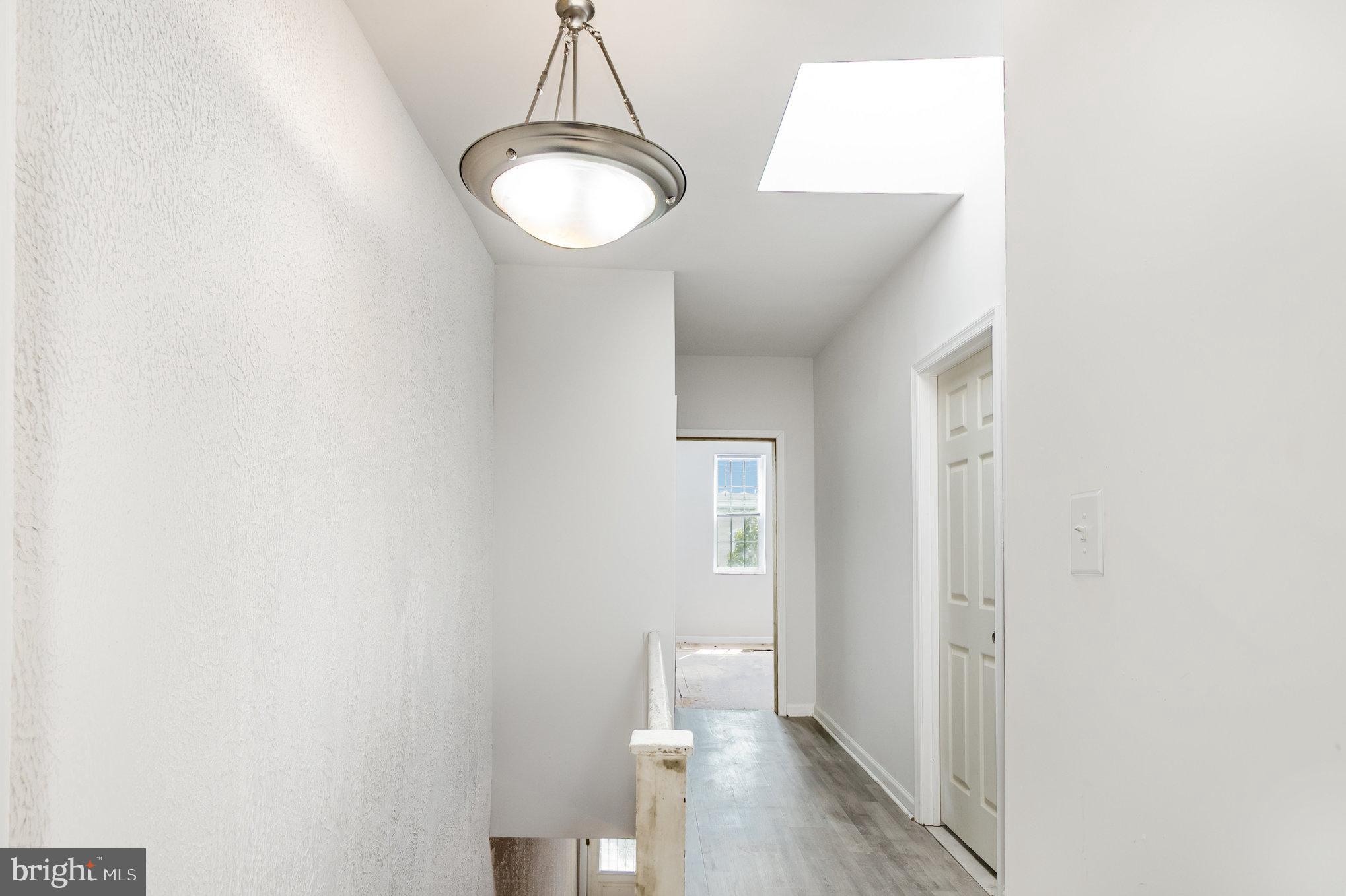 2544 West Fairmount Avenue Baltimore, MD 21223 - Photo 14 of 20 a view of a hallway with wooden floor and a bathroom