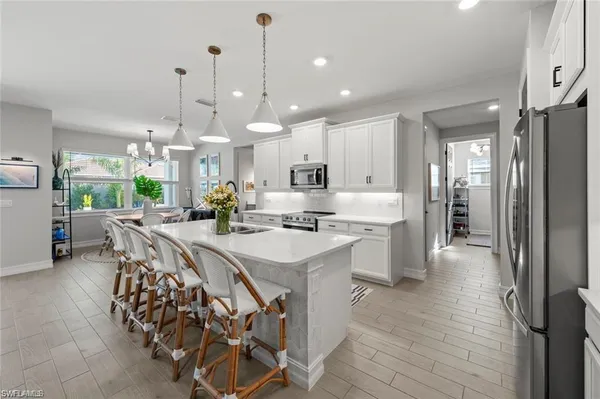 a large kitchen with kitchen island a sink table and chairs