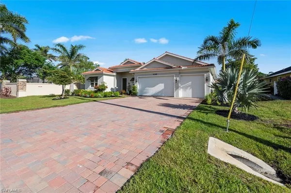 a front view of a house with a yard and potted plants