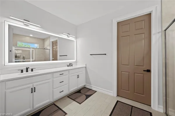 a spacious bathroom with double sink and a mirror