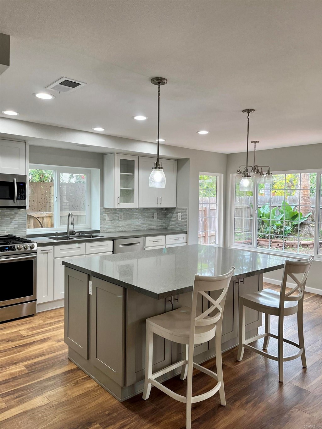 5403 Elderberry Way Oceanside, CA 92057 - Photo 7 of 19 a kitchen with a dining table chairs sink and wooden floor