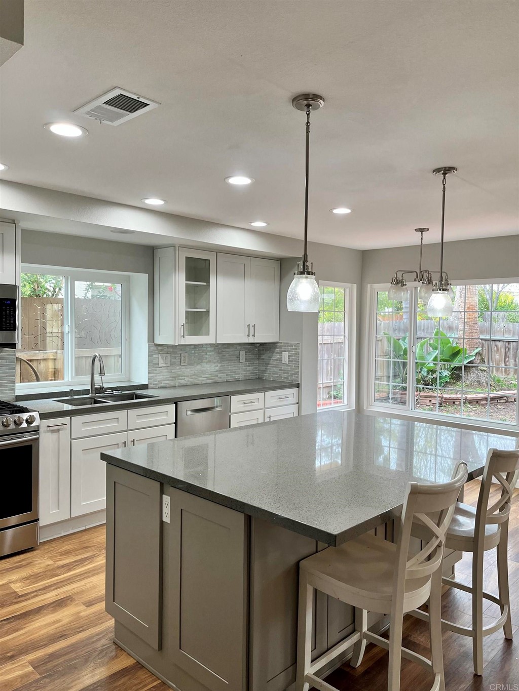 5403 Elderberry Way Oceanside, CA 92057 - Photo 9 of 19 a kitchen with stainless steel appliances granite countertop a stove top oven a sink dishwasher a dining table and chairs with wooden floor