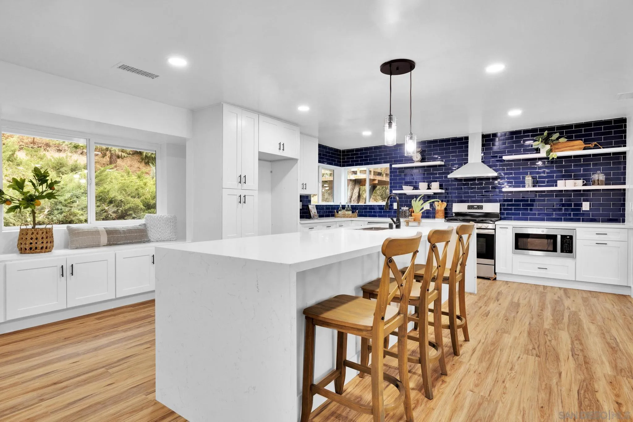 859 Pine Cone Drive Julian, CA 92036 - Photo 7 of 43 a kitchen with stainless steel appliances kitchen island granite countertop a table chairs and a refrigerator