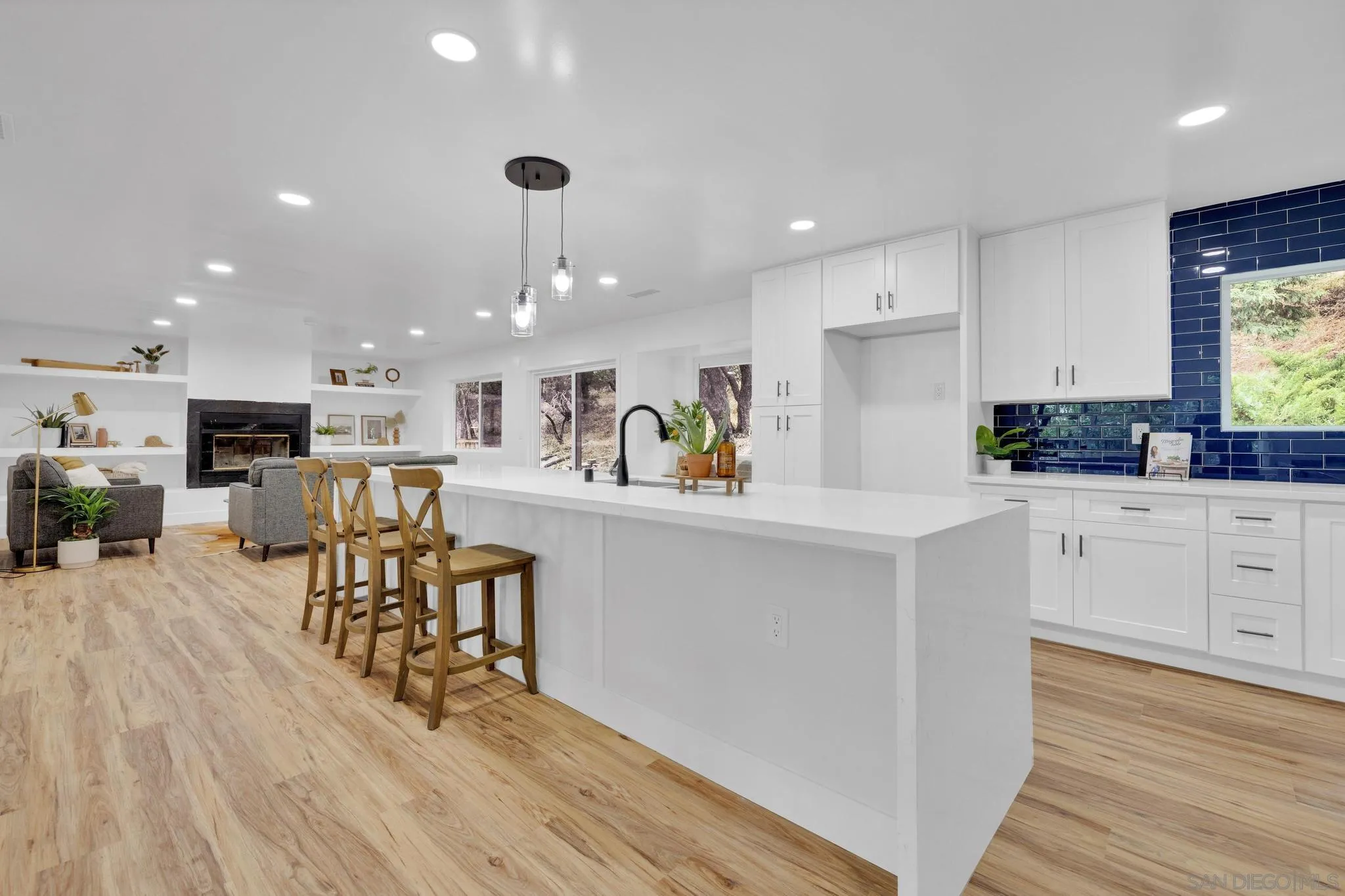 859 Pine Cone Drive Julian, CA 92036 - Photo 10 of 43 a kitchen with a table chairs wooden floors and white cabinets