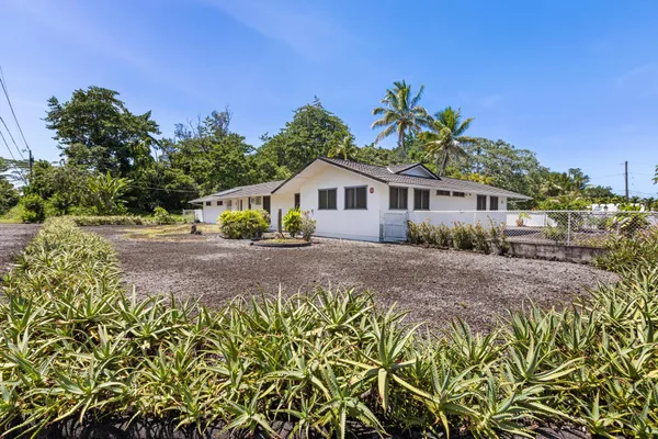 a front view of a house with a yard and potted plants