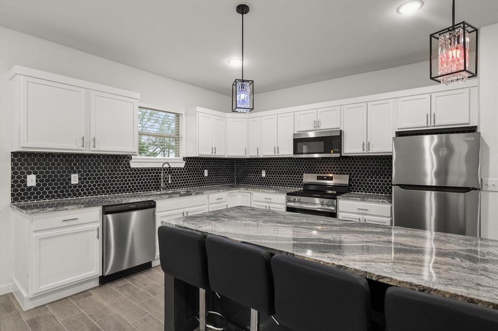 6771 Northwest County Road 1146 Barry, TX 75102 - Photo 14 of 34 a kitchen with a center island and stainless steel appliances