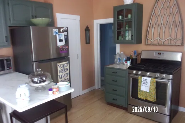 a kitchen with stainless steel appliances granite countertop a refrigerator and a stove top oven