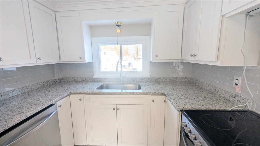 69 Main Street, Unit 2 Foxboro, MA 02035 - Photo 8 of 17 a kitchen with granite countertop white cabinets and a sink