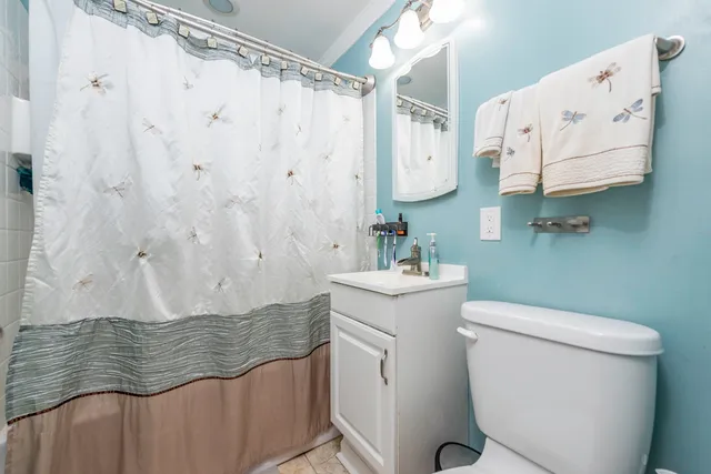 a bathroom with a granite countertop sink and a toilet