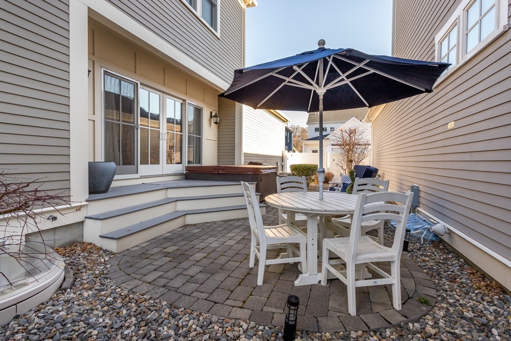8 Cooks Farm Road, Unit 8 Franklin, MA 02038 - Photo 28 of 30 a patio with a table and chairs under an umbrella