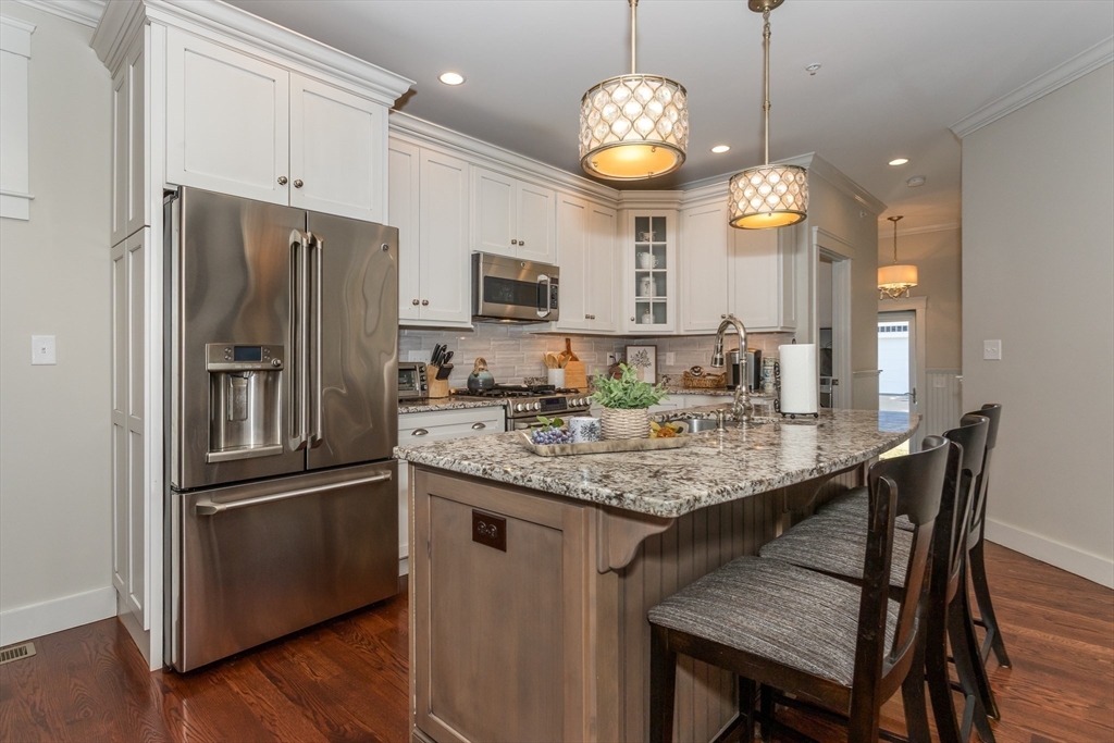 8 Cooks Farm Road, Unit 8 Franklin, MA 02038 - Photo 4 of 30 a kitchen with stainless steel appliances granite countertop a refrigerator a stove a kitchen island a sink dishwasher a refrigerator and a dining table with wooden floor