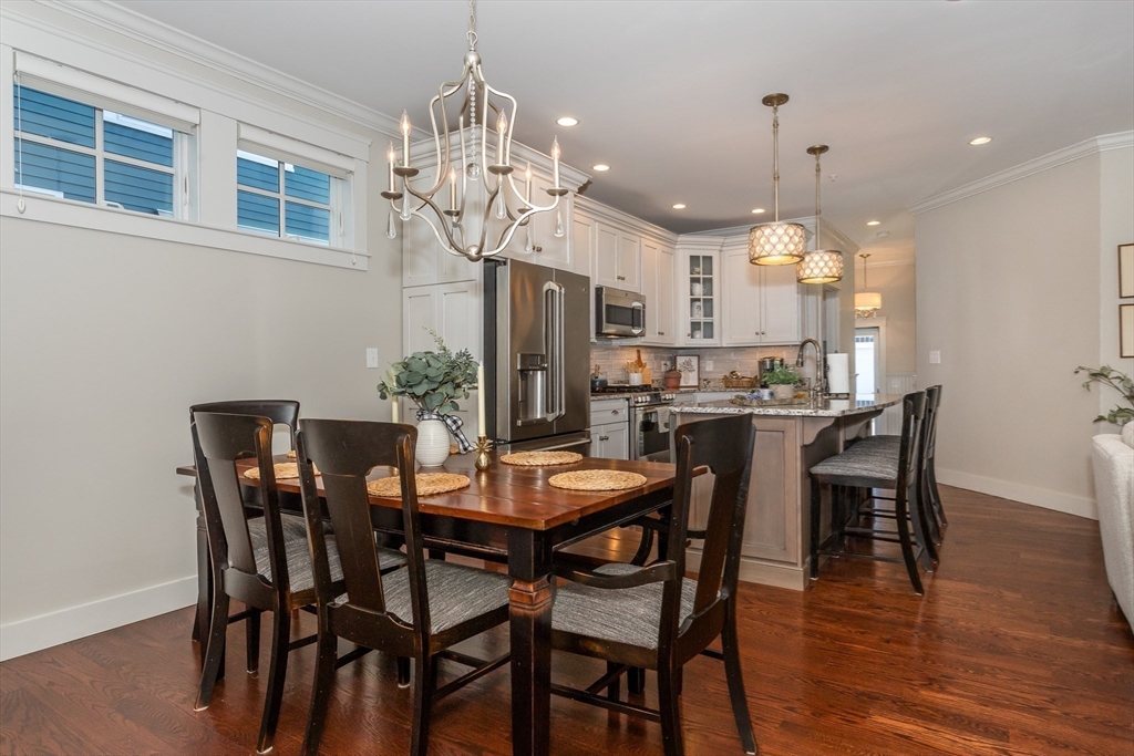8 Cooks Farm Road, Unit 8 Franklin, MA 02038 - Photo 9 of 30 a view of a dining room and livingroom with furniture wooden floor a chandelier a wooden table and chairs