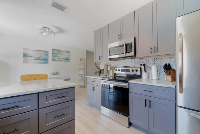 a kitchen with kitchen island a sink stove and chairs