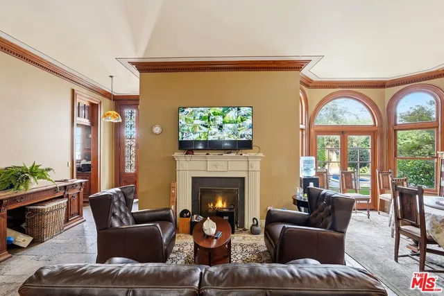 a living room with furniture a fireplace and a floor to ceiling window