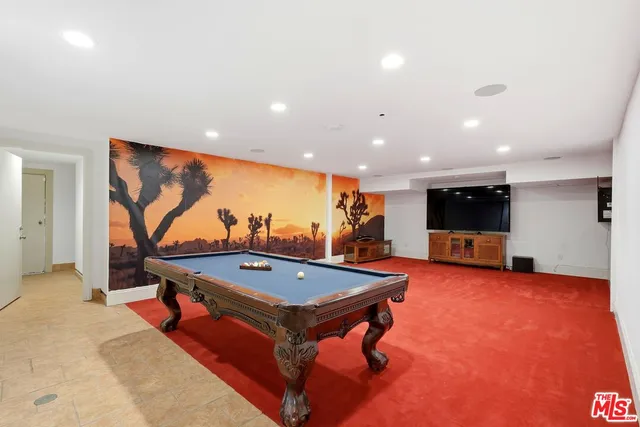 a living room with pool table and a flat screen tv