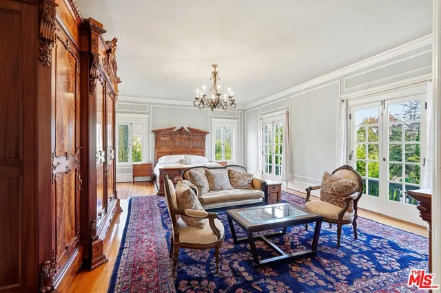 a living room with furniture a chandelier and a window