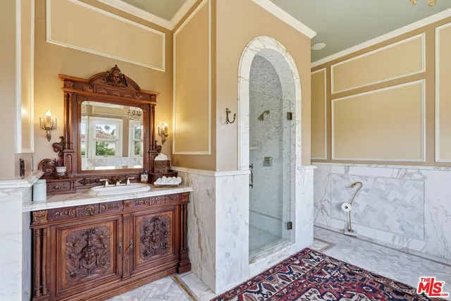 a bathroom with a granite countertop sink a mirror and a shower