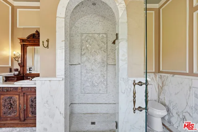 a bathroom with a granite countertop shower sink vanity and toilet