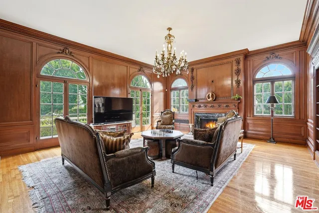 a living room with fireplace furniture and a large window