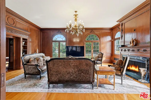 a living room with furniture a fireplace and a chandelier