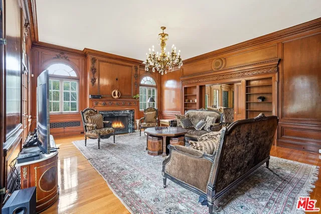 a living room with furniture a fireplace and large windows