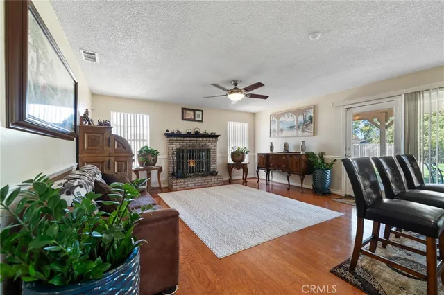 a living room with furniture a fireplace a potted plant and a window