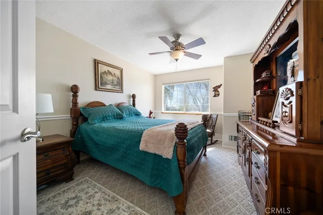 a spacious bedroom with a bed a dresser and a window
