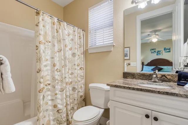 a bathroom with a granite countertop sink toilet and shower