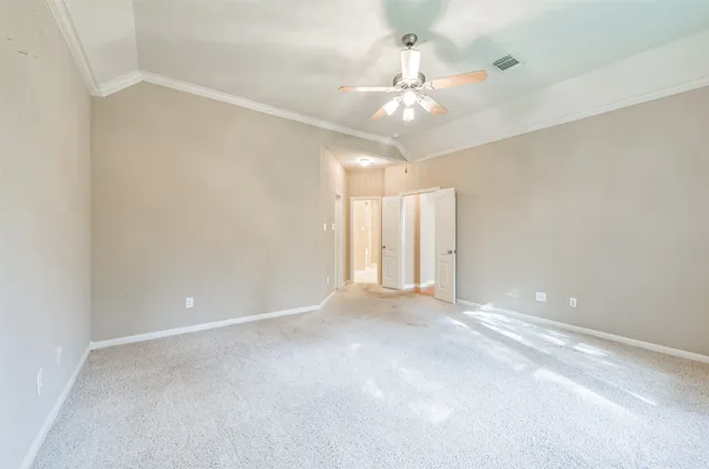 wooden floor in an empty room with a chandelier fan