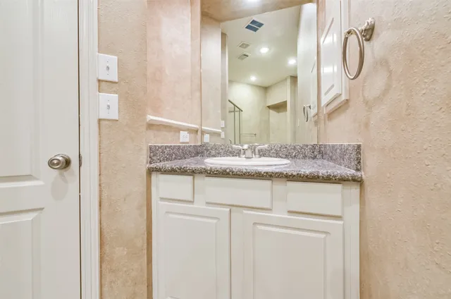 a bathroom with a granite countertop sink vanity and a mirror