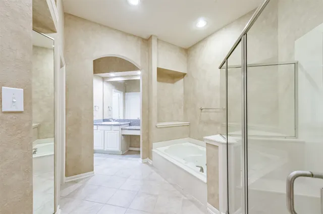 a bathroom with a tub shower and sink