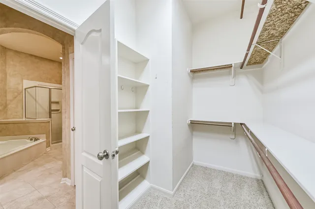 a view of walk in closet with empty racks