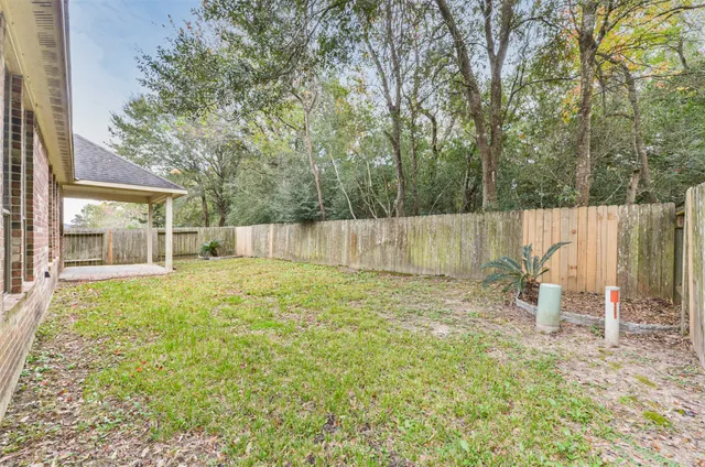 a view of a backyard with table and chairs and wooden fence