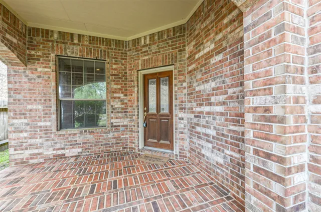 a view of a brick buildings with entryway and wooden floor