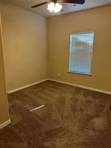 a view of an empty room with a chandeliers fan