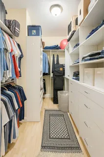 a view of walk in closet with clothes and shoes