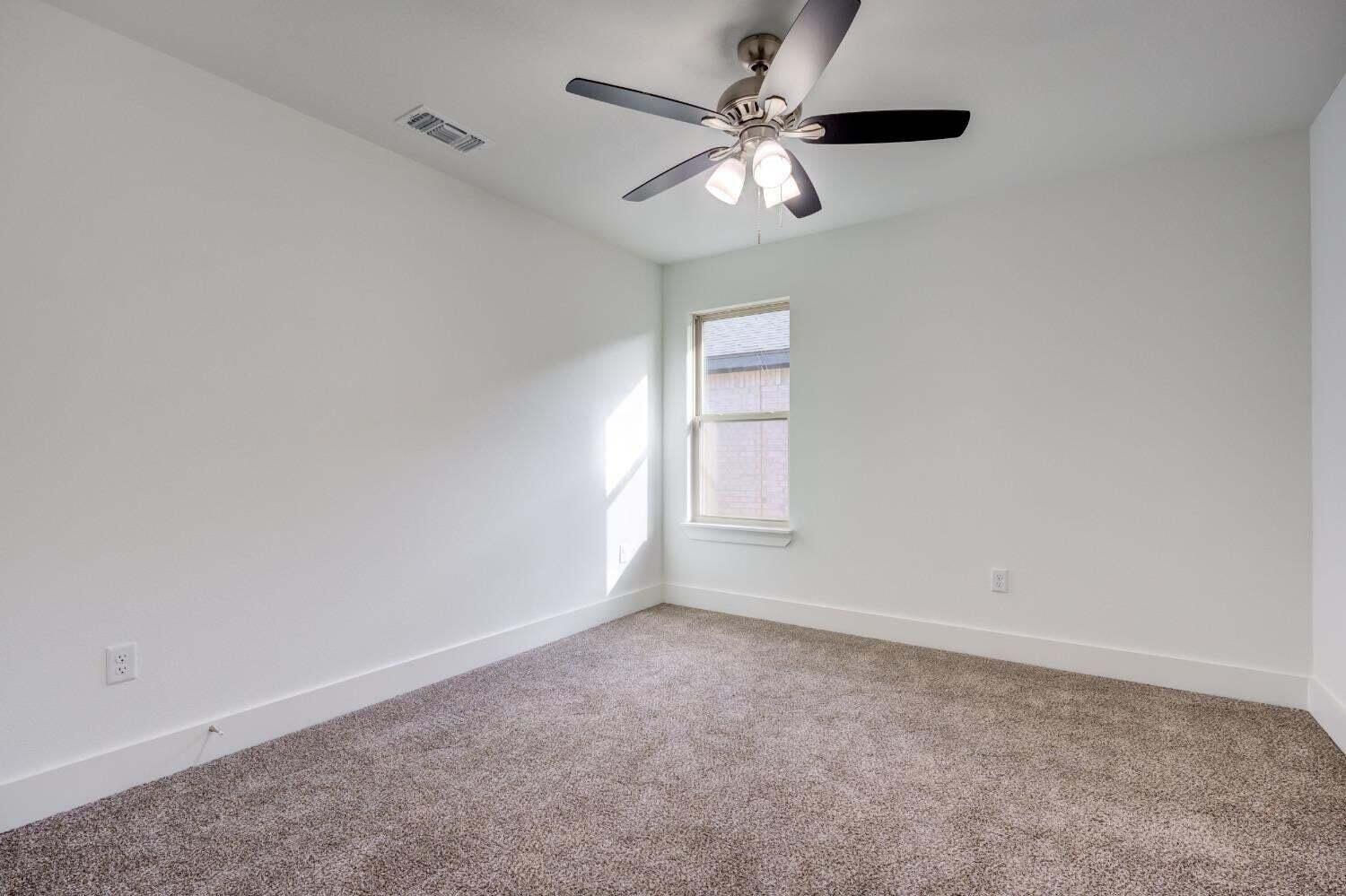 7808 97th Street Lubbock, TX 79424 - Photo 11 of 38 an empty room with a window and a fan