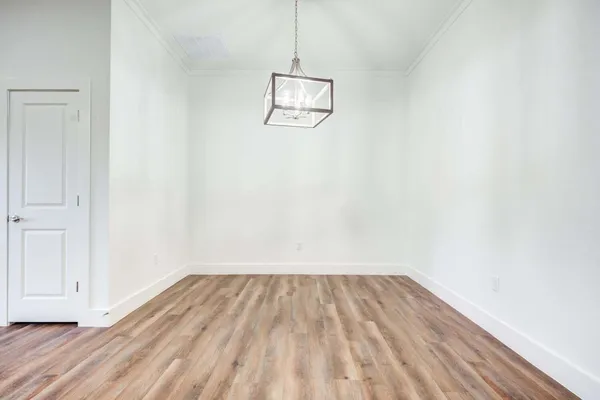 a view of a room with wooden floor and white walls
