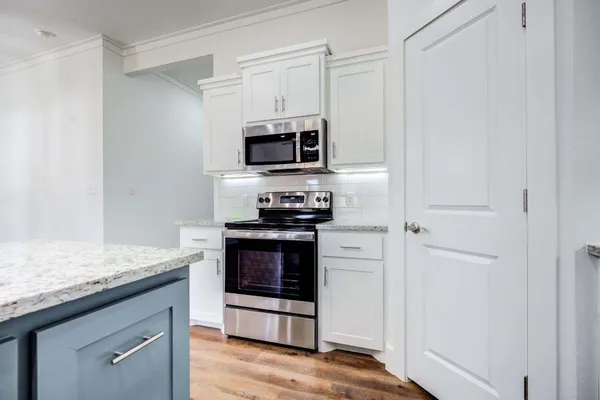 a kitchen with stainless steel appliances granite countertop a stove microwave and sink
